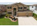 Two-story house with a three-car garage and landscaped yard at 18774 Malinche Loop, Spring Hill, FL 34610