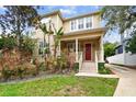 Two-story house with red door, front porch, and well-maintained lawn at 3104 W Fielder St, Tampa, FL 33611