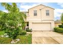 Two story house with beige exterior, two car garage, and palm trees at 409 Serenity Mill Loop, Ruskin, FL 33570