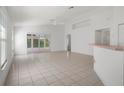 Spacious living room featuring tile floors and access to the outdoor screened lanai at 11230 Heathrow Ave, Spring Hill, FL 34609
