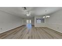 Spacious living room featuring wood flooring, a ceiling fan, and an elegant chandelier at 2607 Royal Ridge Dr, Spring Hill, FL 34606