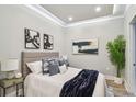 Cozy bedroom featuring tray ceilings, neutral walls, and decorative throw pillows and blankets at 912 Channelside Dr # 2316, Tampa, FL 33602