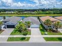 Aerial view of a house and neighborhood by the lake at 15449 Santa Pola Dr, Wimauma, FL 33598