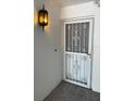 Front door entry with security door and ornate light fixture at 1655 S Highland Ave # F133, Clearwater, FL 33756