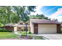Brick house with attached garage and landscaped front yard at 35070 Smoketree Ln, Dade City, FL 33523