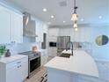 Bright and airy kitchen with white cabinetry, stainless steel appliances and an island at 18390 Fremont Ave, Port Charlotte, FL 33954