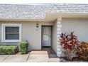 Condo's front entrance with gray walls, private entry and landscaping at 3332 Scorecard Dr, New Port Richey, FL 34655