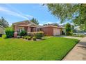 Single-story home with landscaped yard and two-car garage at 10906 Holly Cone Dr, Riverview, FL 33569