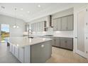 Island kitchen with stainless steel appliances and white quartz countertops at 10324 Longmeadow Ave, Parrish, FL 34219