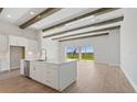 Kitchen with island, white cabinets, and wood beams at 10422 Longmeadow Ave, Parrish, FL 34219
