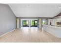 Spacious living room with light wood floors and access to patio at 1826 Wolf Laurel Dr, Sun City Center, FL 33573