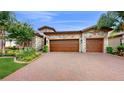Two-story house with stone facade and three-car garage at 11411 Drifting Leaf Dr, Riverview, FL 33579