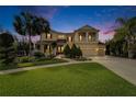 Elegant two-story home with a manicured lawn, lush landscaping, and a welcoming double-door entrance at 19300 Lonesome Pine Dr, Land O Lakes, FL 34638