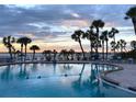 Inviting community pool area with palm trees and sunset views at 100 Bluff View Dr # 605A, Belleair Bluffs, FL 33770