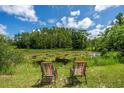 Relaxing lake view with lily pads and comfortable chairs at 11933 Pasco Trails Blvd, Spring Hill, FL 34610