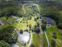 Aerial view of property with pond and surrounding land at 11933 Pasco Trails Blvd, Spring Hill, FL 34610