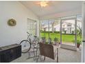 Bright sunroom with comfy seating, bicycle, and view of backyard at 4137 Edgewood Dr, Holiday, FL 34691