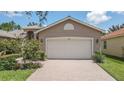 House exterior featuring a two-car garage and manicured lawn at 16252 Amethyst Key Dr, Wimauma, FL 33598