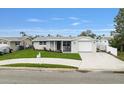 Newly renovated home with a modern exterior and landscaped lawn at 2624 Society Dr, Holiday, FL 34691