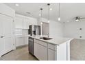 Open kitchen with stainless dishwasher and modern island seating area at 12729 Wanderlust Pl, Parrish, FL 34219