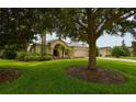 Landscaped front yard with lush lawn and large tree at 13322 Trailing Moss Dr, Dade City, FL 33525