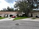 Exterior view of two tan houses with garages and driveways at 35226 Janine Dr, Zephyrhills, FL 33541