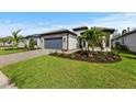 One-story house with gray garage door and well-maintained landscaping at 1871 Pepper Grass Dr, North Port, FL 34289