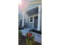 Modern townhome entry with gray door, stone walkway, and red flowers at 5530 N 9Th St # 5, Tampa, FL 33604