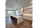 Open kitchen with a large center island, stylish pendant lighting, and stainless steel appliances, perfect for entertaining at 4021 W Santiago St, Tampa, FL 33629