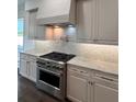 Close up of a modern kitchen featuring custom cabinets, stainless steel appliances, and a stylish subway tile backsplash at 4021 W Santiago St, Tampa, FL 33629