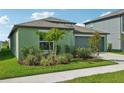 Green house with a two-car garage and nicely landscaped front yard at 13265 Great Plains Dr, Riverview, FL 33579