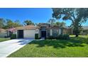 Inviting single-Gathering home with a manicured lawn, two car garage, and a tiled pathway leading to the front entrance at 11416 Billingham Blvd, Spring Hill, FL 34609