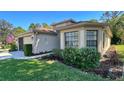 Well-maintained home with neat landscaping, an American flag, and a combination of lawn and garden beds at 11416 Billingham Blvd, Spring Hill, FL 34609