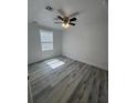 Spacious bedroom with grey wood-look flooring and ceiling fan at 5238 16Th St, Zephyrhills, FL 33542