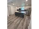 Modern kitchen with white cabinets, stone island, and new flooring at 5238 16Th St, Zephyrhills, FL 33542