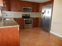 Kitchen with wood cabinets and stainless steel appliances at 7101 Green St, New Port Richey, FL 34652