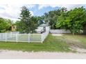 White house with a white picket fence and green lawn at 4622 Paloverde Dr, New Port Richey, FL 34652