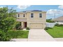 Two-story house with beige exterior, solar panels, and landscaped yard at 11824 Myrtle Rock Dr, Riverview, FL 33578