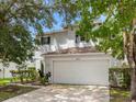 Two-story house with a white garage door and landscaping at 18933 Sunterra Dr, Land O Lakes, FL 34638