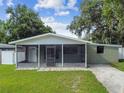 Front view of a charming house with a screened porch at 7024 Filbert Ln, Tampa, FL 33637