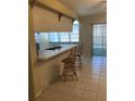 Kitchen with breakfast bar and view to backyard at 13806 Capitol Dr, Tampa, FL 33613