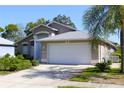 Well-kept home featuring a spacious driveway and lush, verdant landscaping at 13451 Knotty Ln, Hudson, FL 34669