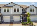 Two-story townhome with gray siding and two-car garage at 21868 Lyonia Ln, Land O Lakes, FL 34637