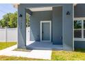 Inviting entryway with a modern blue door and stylish outdoor lighting at 7422 S 34Th Ave, Tampa, FL 33619