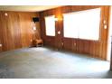 Living room with wood paneled walls and blue carpeting at 22365 Panorama St, Brooksville, FL 34601