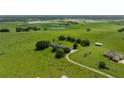 Sprawling estate aerial view showcasing lush green fields, mature trees, and serene ponds, near a well-maintained home at 34868 Prospect Rd, Dade City, FL 33525