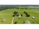 Aerial view of a house on a large lot with a pond and surrounding greenery at 34868 Prospect Rd, Dade City, FL 33525