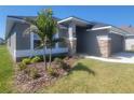 Charming single-story home with a gray facade, stone accents, and a meticulously landscaped front yard at 13260 Ogden Glade Rd, Dade City, FL 33525