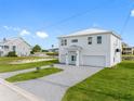 Two-story home with light gray exterior, two-car garage, and landscaped yard at 3455 Sheephead Dr, Hernando Beach, FL 34607