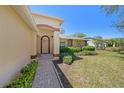 Inviting front entrance with a brick walkway, arched doorway, and lush landscaping at 1145 Almondwood Dr, Trinity, FL 34655